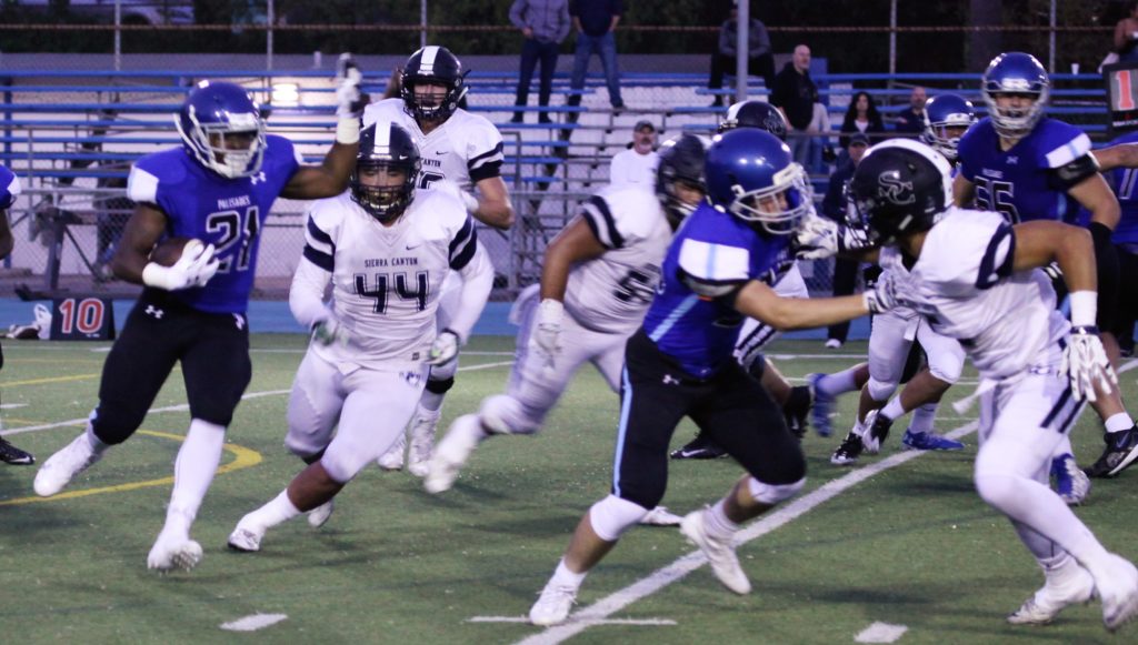 Running back Stone Maderer looks to slip by the Sierra Canyon defense.